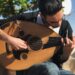 Muzikant bespeelt een oed met een rode plectrum in de buitenlucht