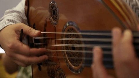 Close-up van handen die op een oed met houten klankkast spelen